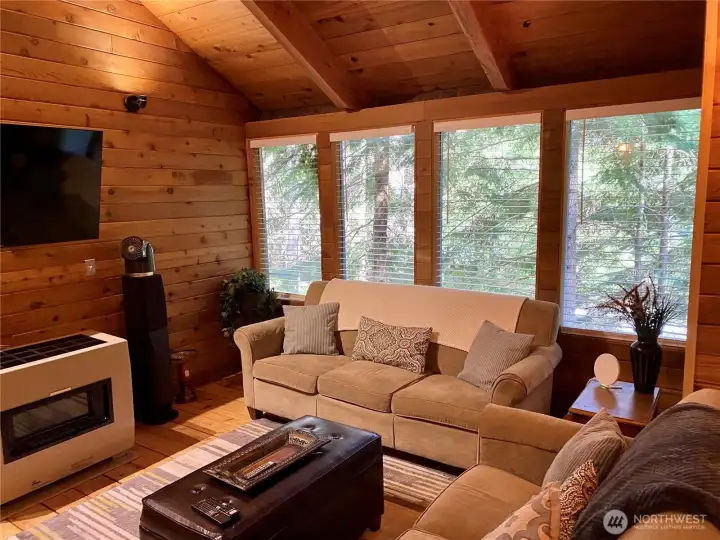 Relax in the inviting living room, where a wall of windows brings the forest indoors, and a cozy gas fireplace sets the perfect mood for unwinding with your favorite show on the 55” TV. Relax in the inviting living room, where a wall of windows brings the forest indoors, and a cozy gas fireplace sets the perfect mood for unwinding with your favorite show on the 55” TV.