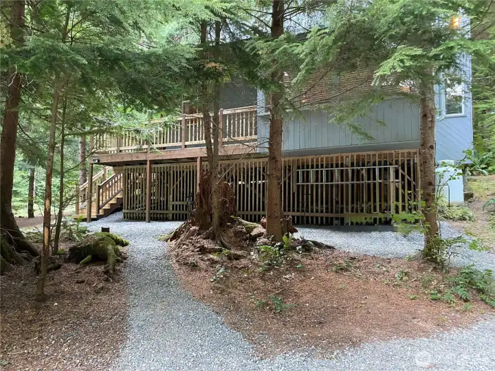 Another view of the home featuring charming gravel walkways that enhance the natural setting. Another view of the home featuring charming gravel walkways that enhance the natural setting.
