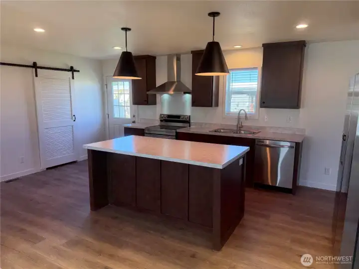 Kitchen w/island eating bar. Barn doors go to utility room.