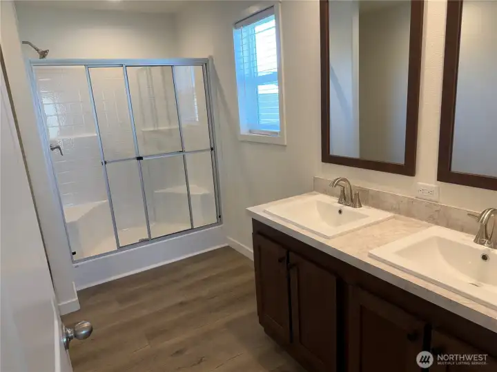 Primary bathroom w/double vanities and walk in shower.