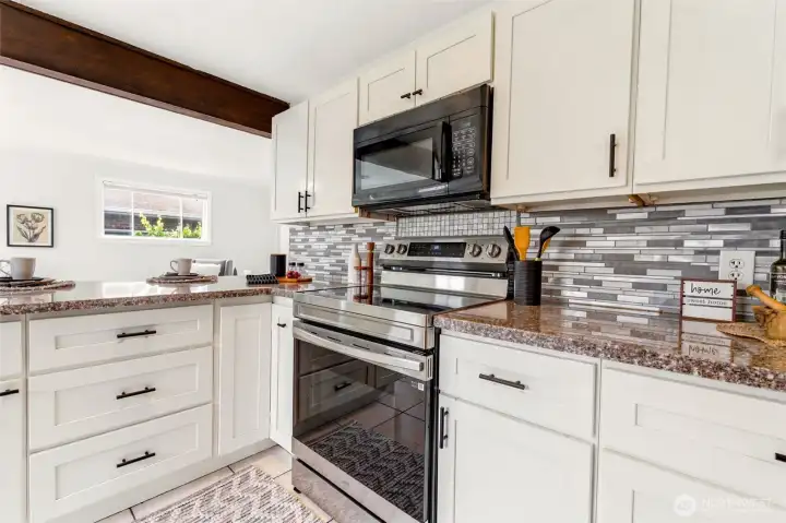 The kitchen features stainless steel appliances and a stylish tile backsplash.