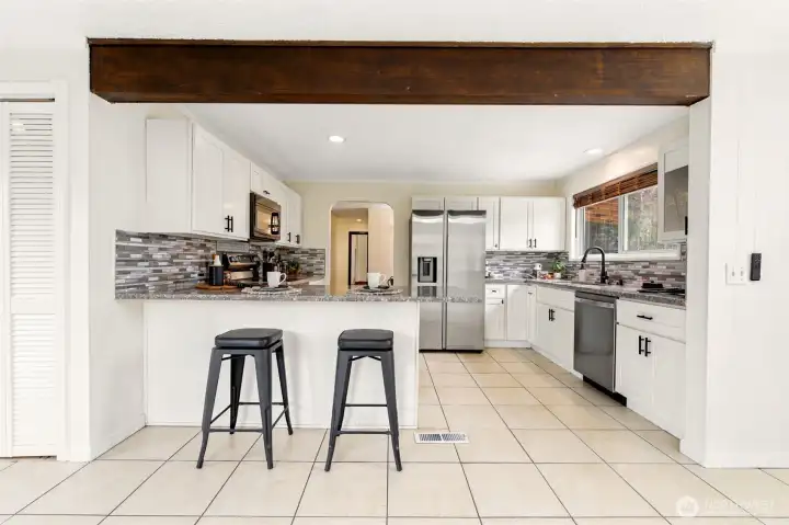 A spacious, open-concept kitchen offers abundant prep space, breakfast seating, and modern finishes throughout.