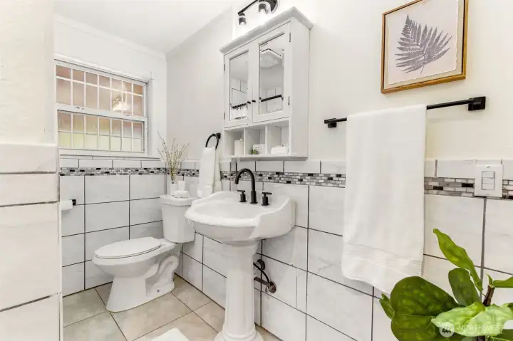 Stylishly updated and full of charm, the guest bathroom combines timeless finishes with practical functionality.