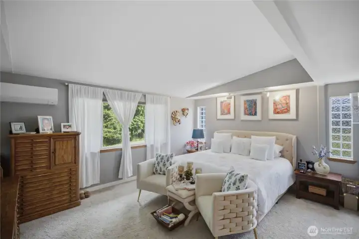 Primary bedroom with vaulted ceilings and newer carpet.