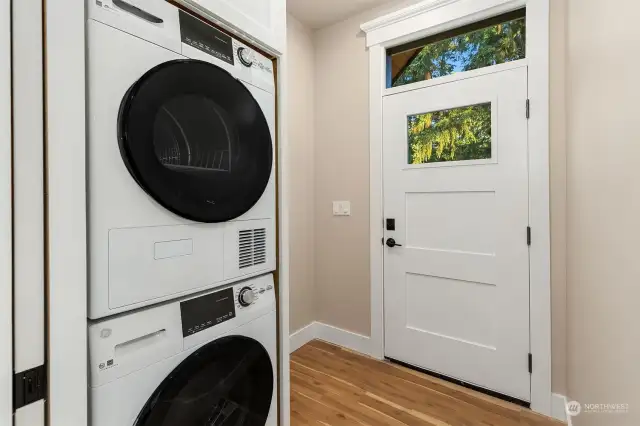 Convenient Mudroom side entryway with built-in stacking laundry and interior pocket door