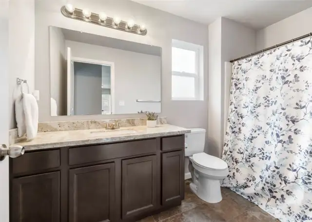 2nd level full bath with matching countertops & cabinets to kitchen.