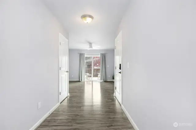 Entry at ground level, wide hallway leading to possible MIL space or recreation room, full bath & a bedroom. Deck outside of the sliding door. Fully fenced yard. Entry from garage is to the right.