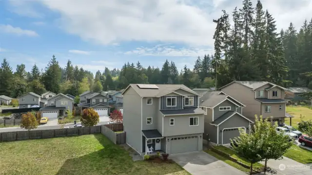 Areal view of home with 1 year old solar on the roof and vacant community land next door.