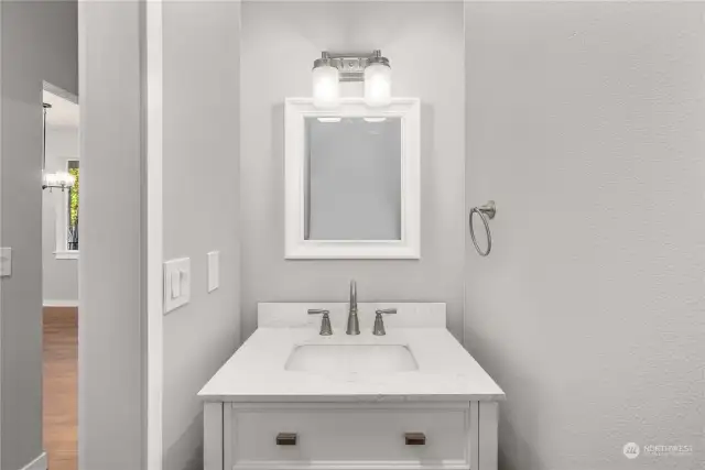 Powder Bath in hallway behind kitchen area allows for easy access for guests.