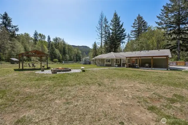 Multiple outdoor living spaces with large firepit off the living room side of the house.