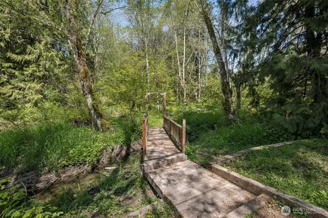 Cross the quiet creek and wander into the wooded part of this 2.16 acre property.