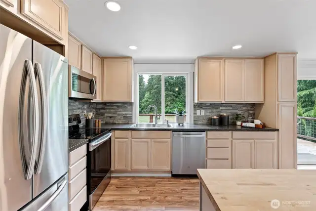 The kitchen includes an island with storage, SS appliances, and laminate flooring.  Enjoy your views from the kitchen window as you do dishes or prepare a meal.