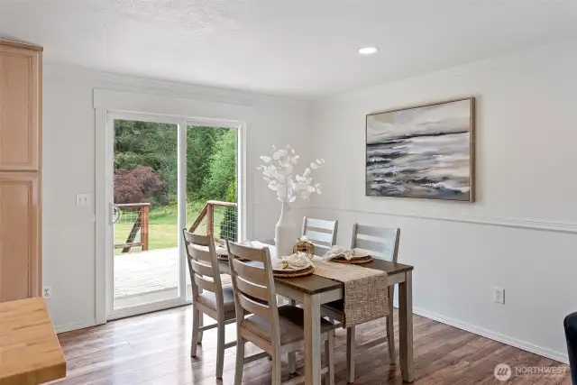 The dining room enjoys easy access to the expansive deck, perfect for barbecuing and enjoying the lovely acreage.