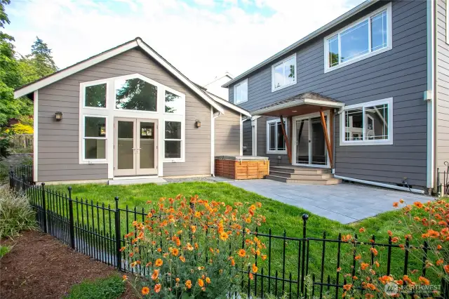 The beautiful, private  backyard with lush landscaping, patio and hot tub.