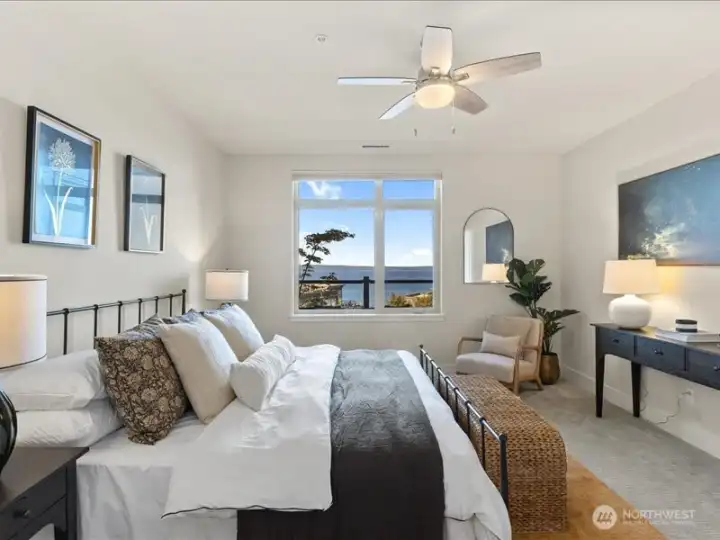 Primary bedroom is generous and enjoys the view . . .