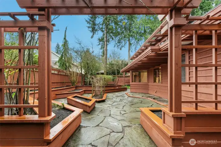 Stone-paved patio area with raised garden beds