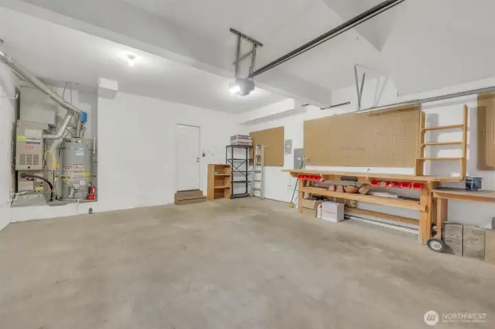 Large 2 car garage with shelving and work bench.