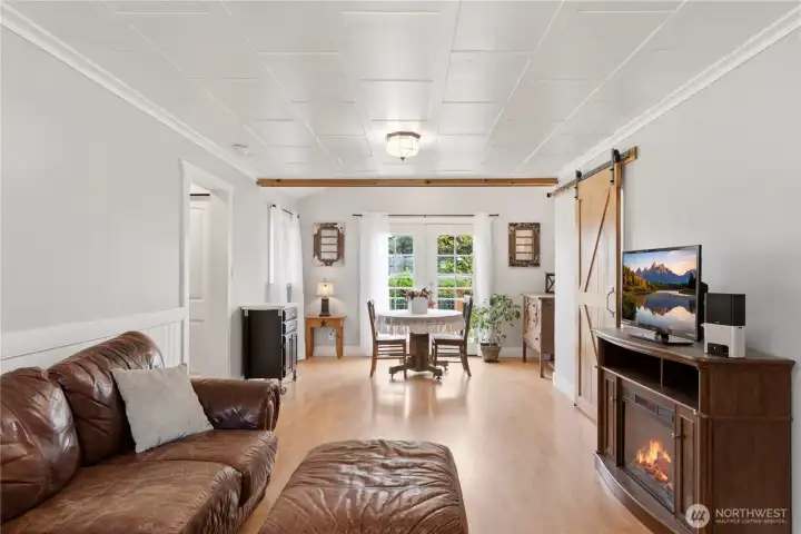 Living room view towards the back of the home. Barndoor lead to the kitchen. Step out of the French doors onto the expansive Trex deck!