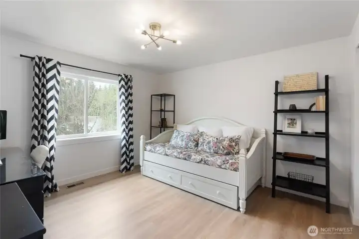 First bedroom offering ample natural light, updated flooring, and modern lighting, creating a comfortable and flexible space for guests, home office, or everyday use.