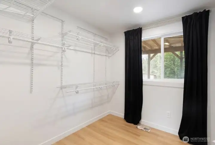 Oversized walk in closet that has a door leading you directly to the fully remodeled primary bathroom.