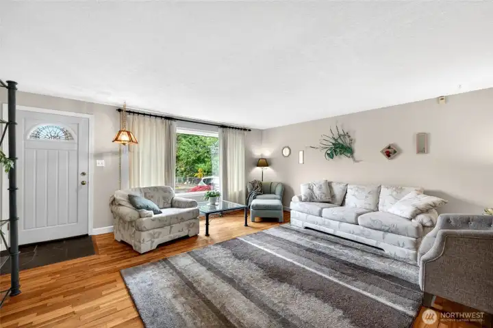 Bright and comfortable gathering space featuring large picture windows, abundant natural light, and plenty of room for multiple seating arrangements.
