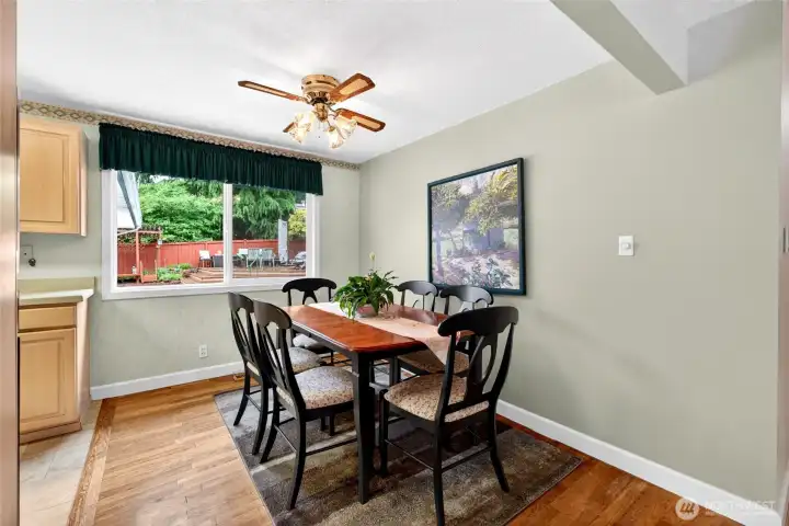 Bright dining area with large windows overlooking the backyard patio, creating an inviting space for everyday meals and entertaining.