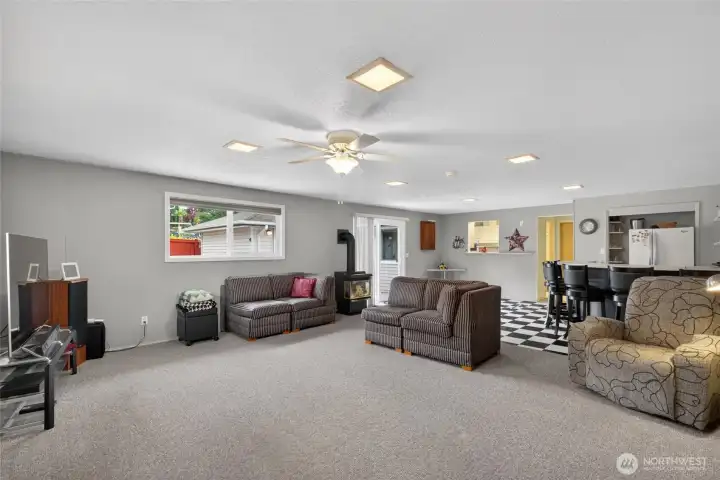 Massive bonus and recreation room with flexible open living space, cozy freestanding fireplace, and easy access to the outdoor patio for seamless entertaining.