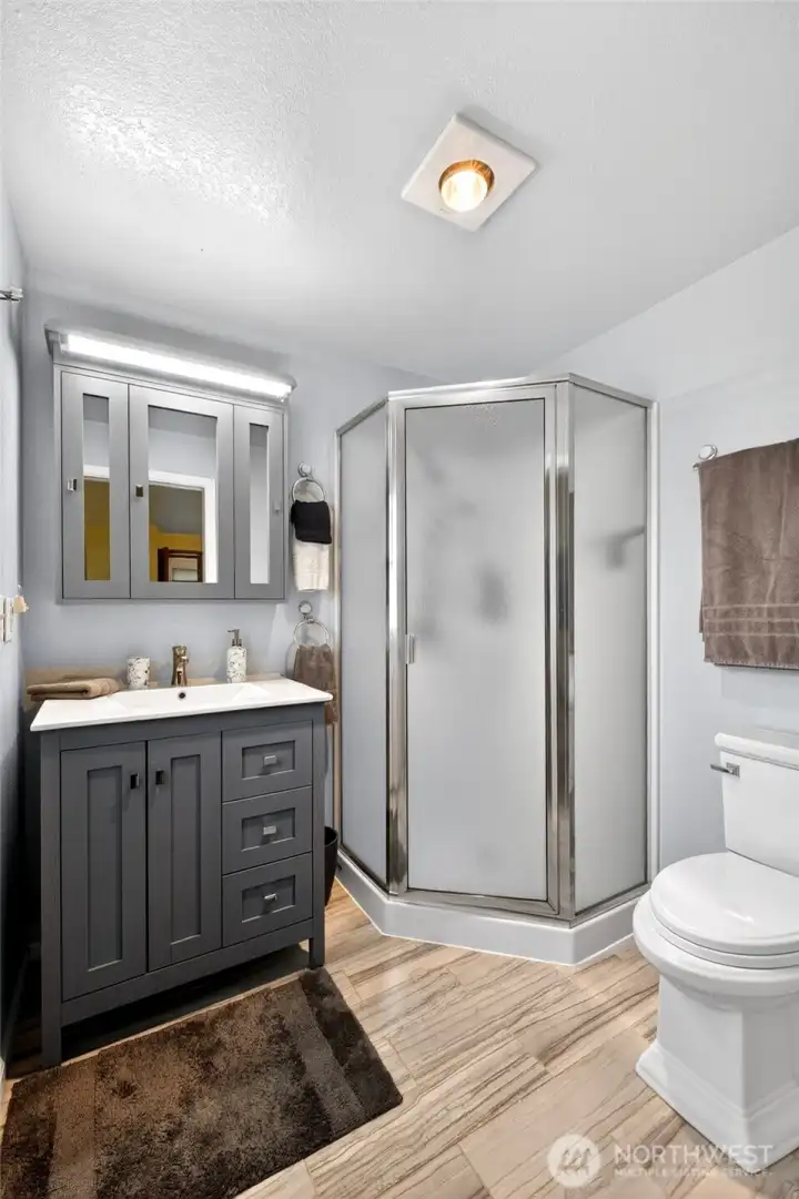 Updated bathroom featuring a modern vanity, stylish fixtures, and a walk-in shower with contemporary finishes.