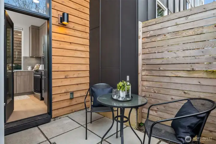 The side patio off the kitchen. The outdoor storage unit is to the left of the door (not pictured)