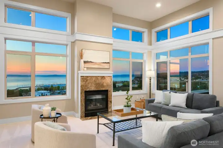 Sunset colors frame the living area, highlighting the home’s dramatic windows and view-focused design.