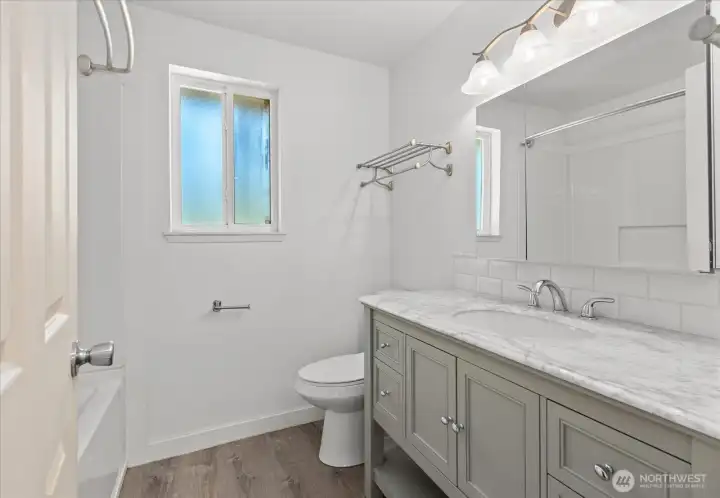 Unit 2: Upper floor, Remodeled bath: vinyl plank flooring and vanity with stone counters Unit 2: Upper floor, Remodeled bath: vinyl plank flooring and vanity with stone counters