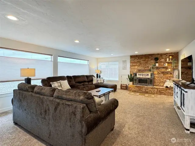Open living room with recessed lighting and a fireplace