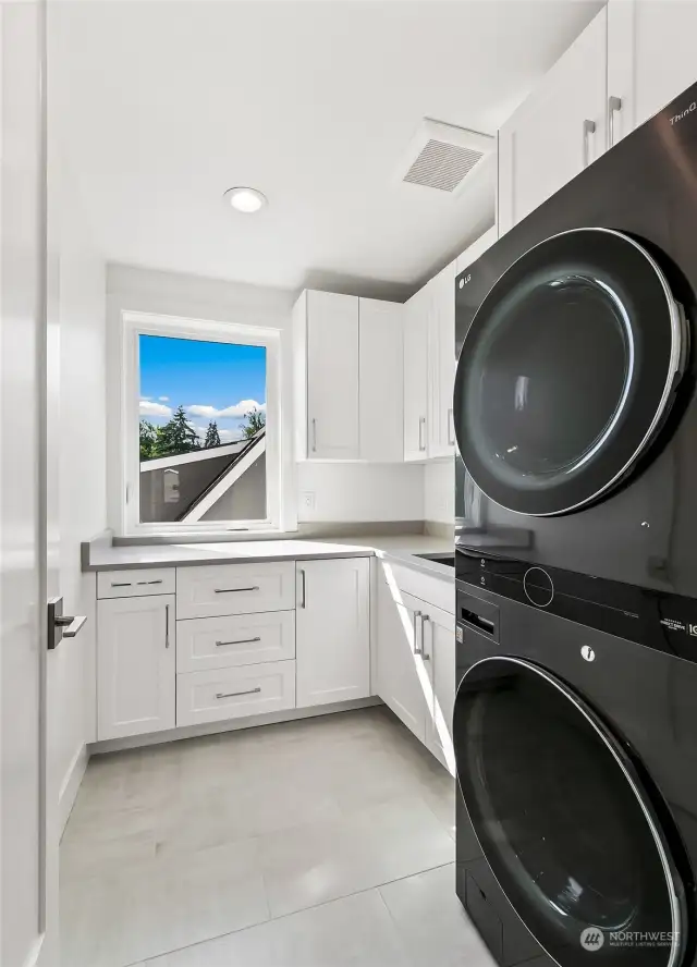 The laundry room with storage cabinets and premium full size washer and dryer is conveniently located between bedrooms for easy access.