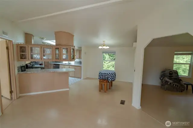 Another view of the main room with view of bonus room, dining and kitchen.