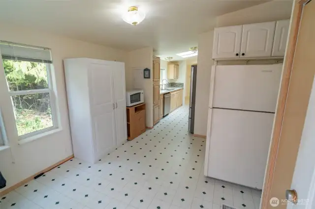 Behind the kitchen where the washer and dryer and an extra fridge/freezer.