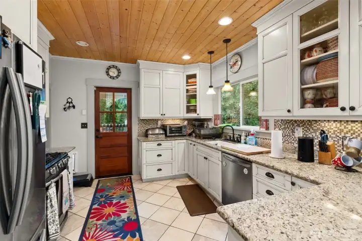 Modern kitchen, quartz/granit counters, modern appliances,  door to back porch.