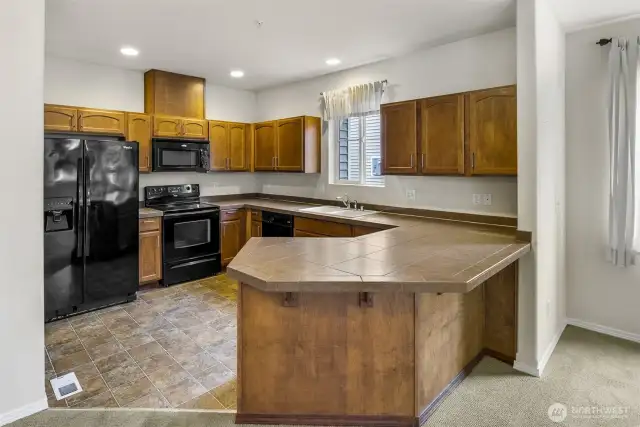 Peninsula counter with eating bar separates living space from Kitchen.