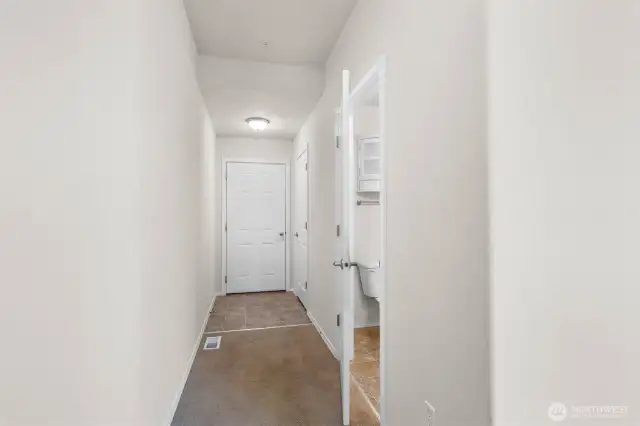 Hallway leads to the attached two car garage. Convenient powder room on the right.