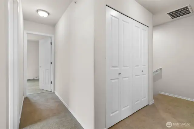 Landing area at top of stairs with laundry closet.
