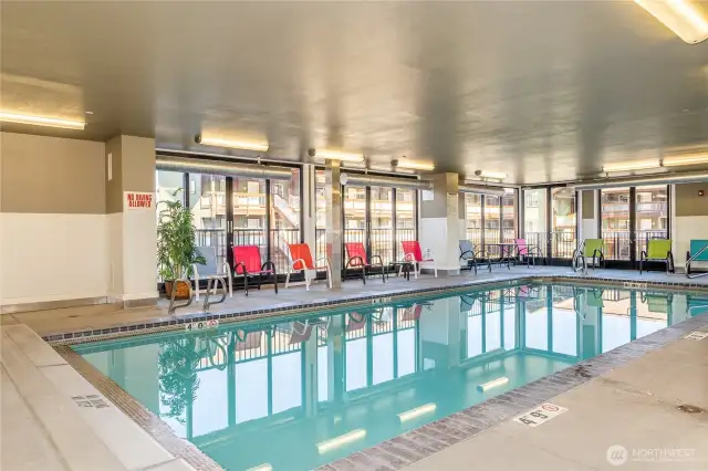 Indoor heated pool with plenty of chairs and natural light