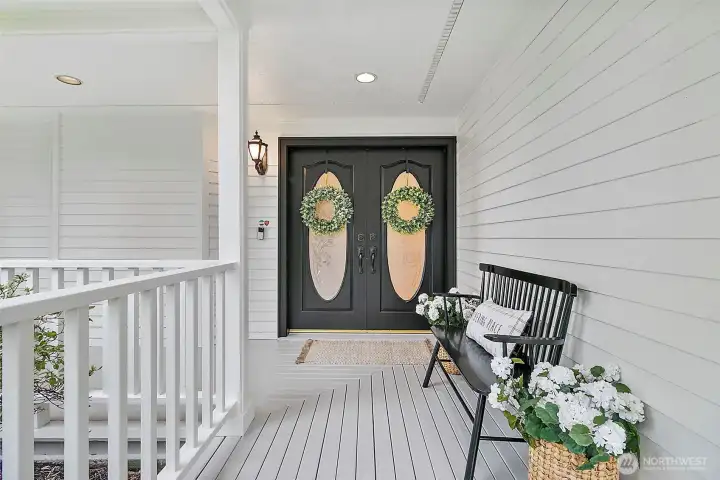 Wrap around porch with grand doors.