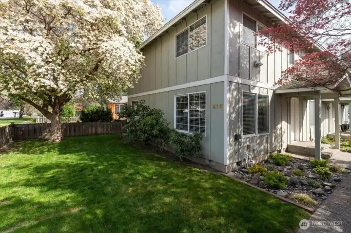 Exterior view of corner end unit with spacious landscaped yard.