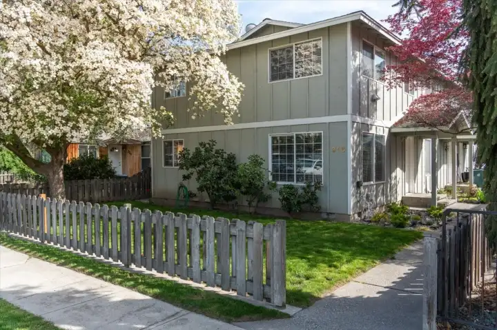 Exterior view with landscaped yard and fence.