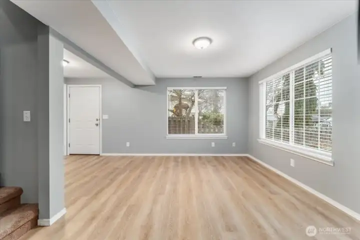 Main level living room looking towards front for and staircase to the upper level.