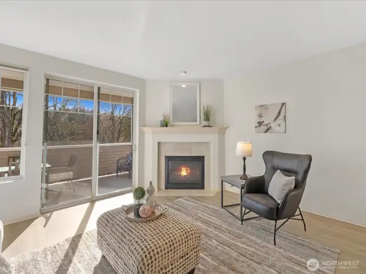 Living room with gas fireplace and direct access to covered deck, providing natural light and indoor-outdoor connection.