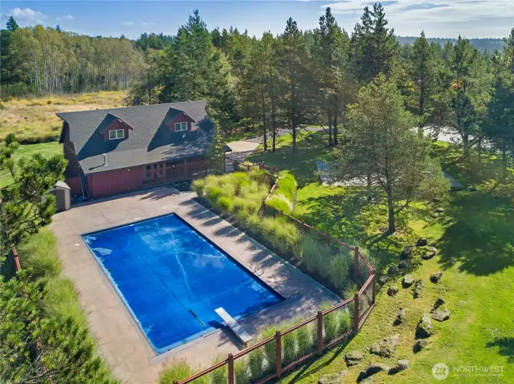 Resort-style outdoor living awaits with a private swimming pool, expansive entertaining space, and beautifully landscaped grounds surrounding the barn.