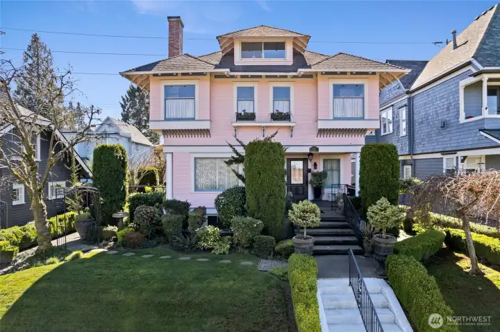 Dream Four Square in Tacoma’s North Slope Historic District.  Distinguished façade captivates with carved rafters & grand approach leading to expansive covered front porch adorned with statuary  & symmetrical plantings..