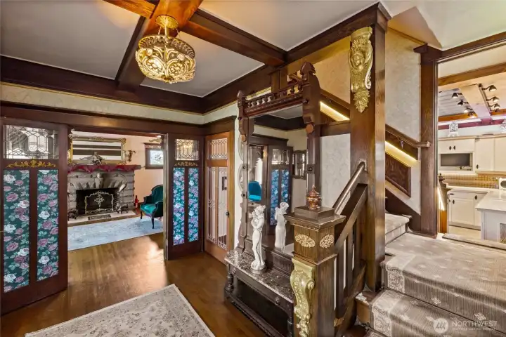 Second view of the entry with ornate details.  Split landing on the stairwell from the entry & the kitchen.  Beautiful wool carpet highlights the rich wood finishes.