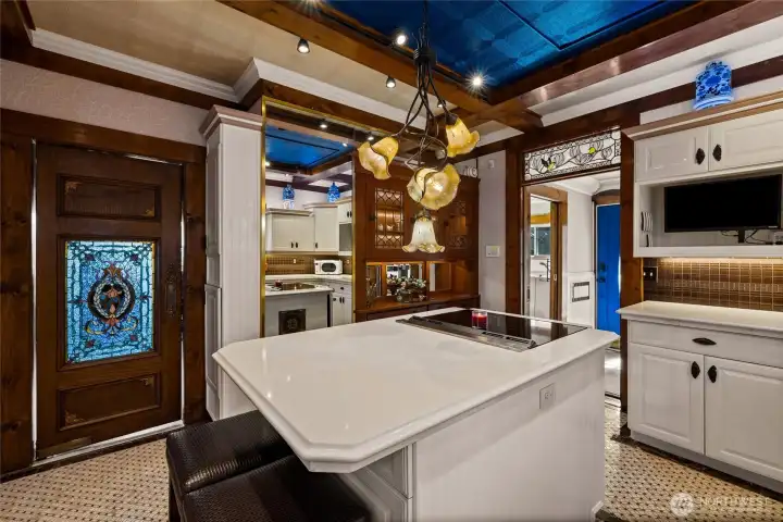Swinging door with stained glass panel leads to the dining room.