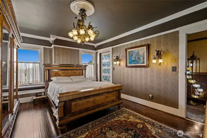 Striking bedroom on the second floor with hand cast chandelier & wall sconces.